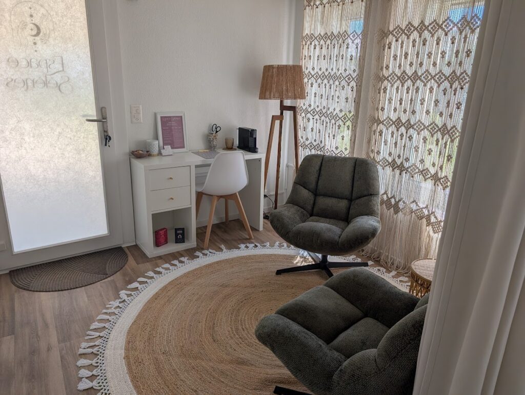 Entrée de l'Espace Sélènes avec 2 fauteuils, et un bureau. Le tout agencé dans un espace cosy.