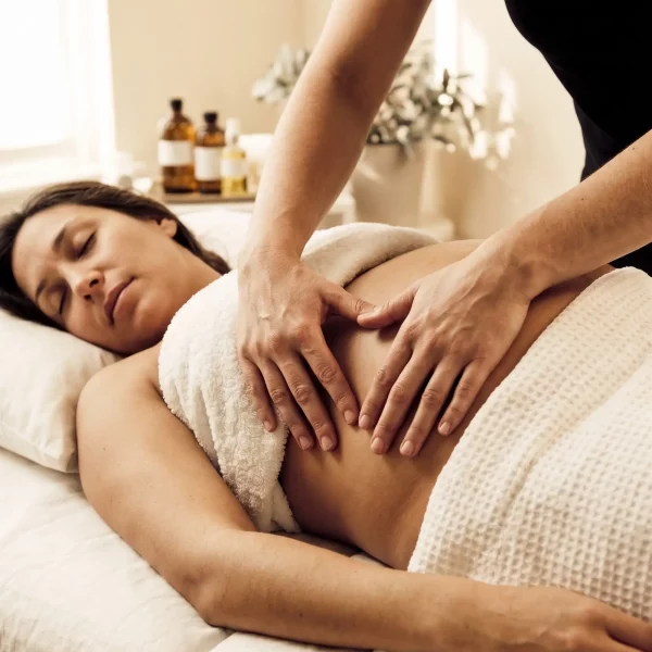 Une femme reçoit un massage prénatal sur le ventre.